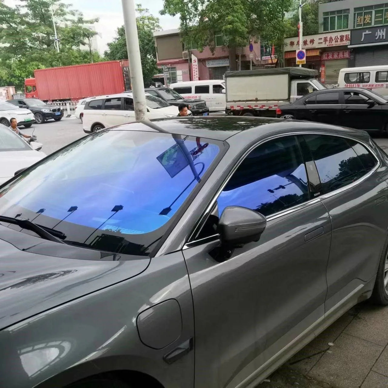 Chameleon Blue Reflective Windshield Film applied on a sleek gray vehicle, showcasing its unique blue gradient and reflective properties.